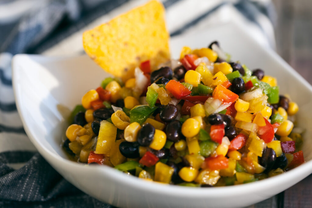 “Colorful Southern Cowboy Caviar in a white bowl with black-eyed peas, corn, bell peppers, and cilantro.”